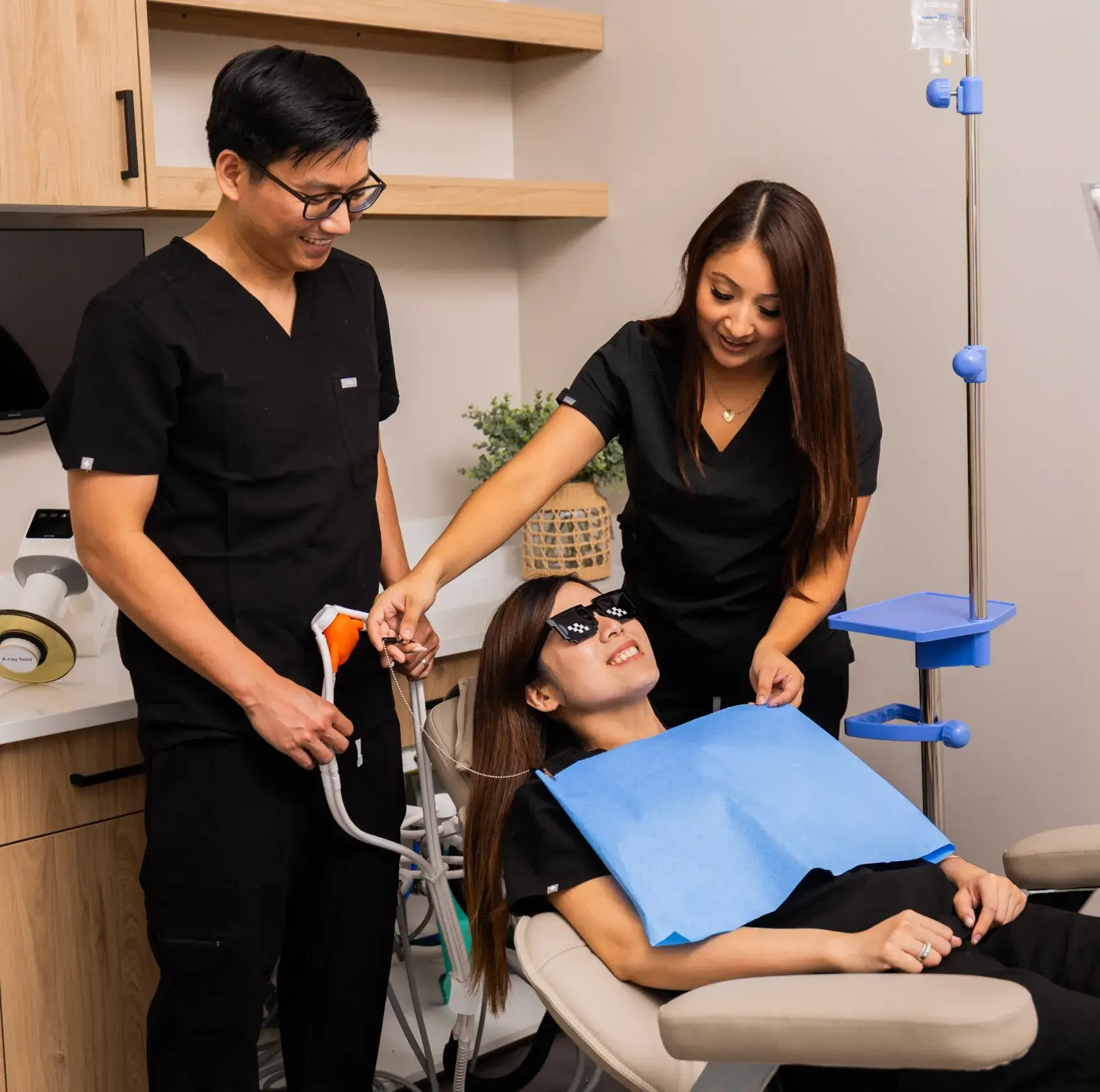 Dr. Huynh and a dental assistant at AsterSmiles providing gentle care to a patient in a modern dental chair.